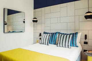 Chambre supérieure avec lit double et draps jaunes